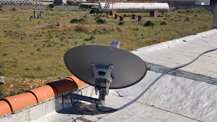 Vue de l'antenne VSAT orientée vers le satellite avec environnement industriel en arrière-plan - installation UBSM Maroc