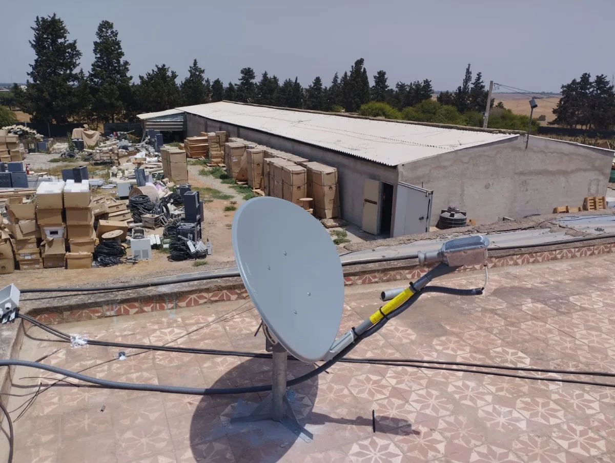 Antenne parabolique VSAT Ka-band orientée vers le satellite, vue depuis la toiture d'un entrepôt près de Rabat